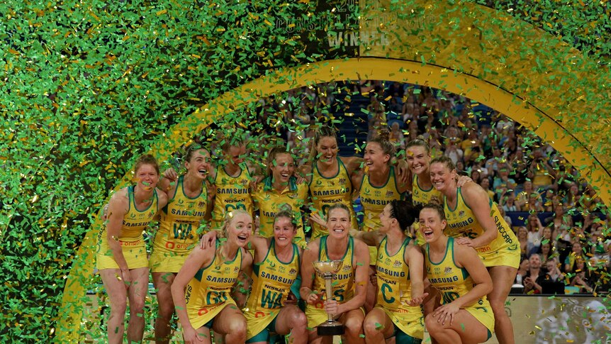 Australia's Diamonds celebrate with the Constellation Cup as confetti falls on them.