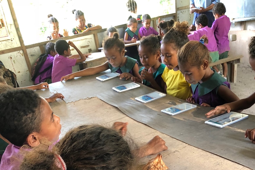 School children n the Central Province of PNG read stories from Library for All.