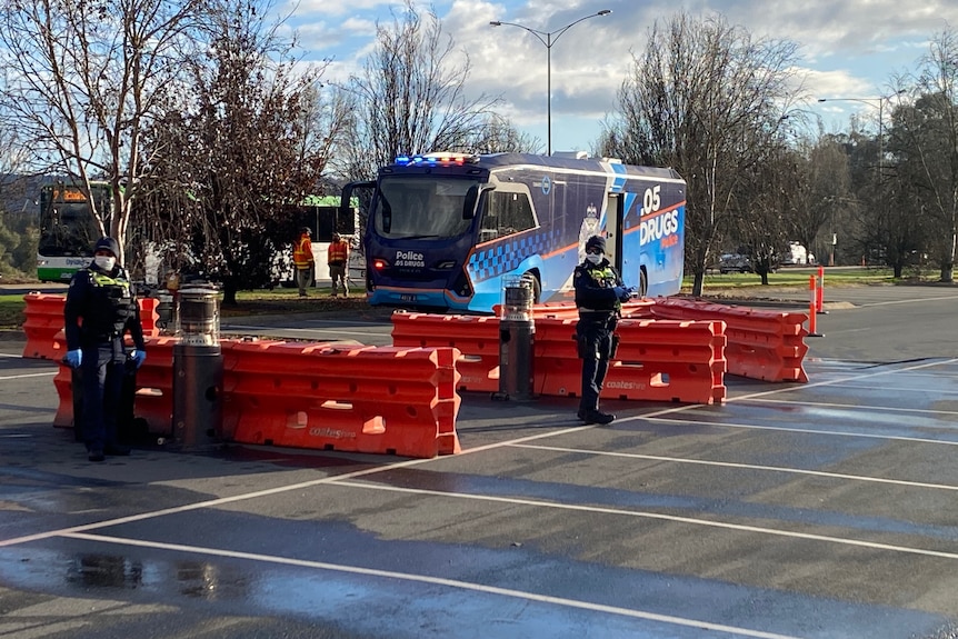 Police stand on a road.