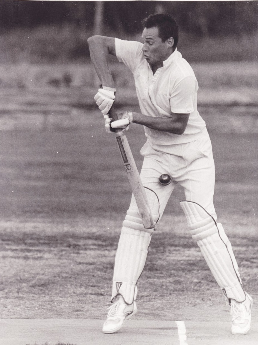 A cricketer in a black and white photo gets hit in the groin with a ball