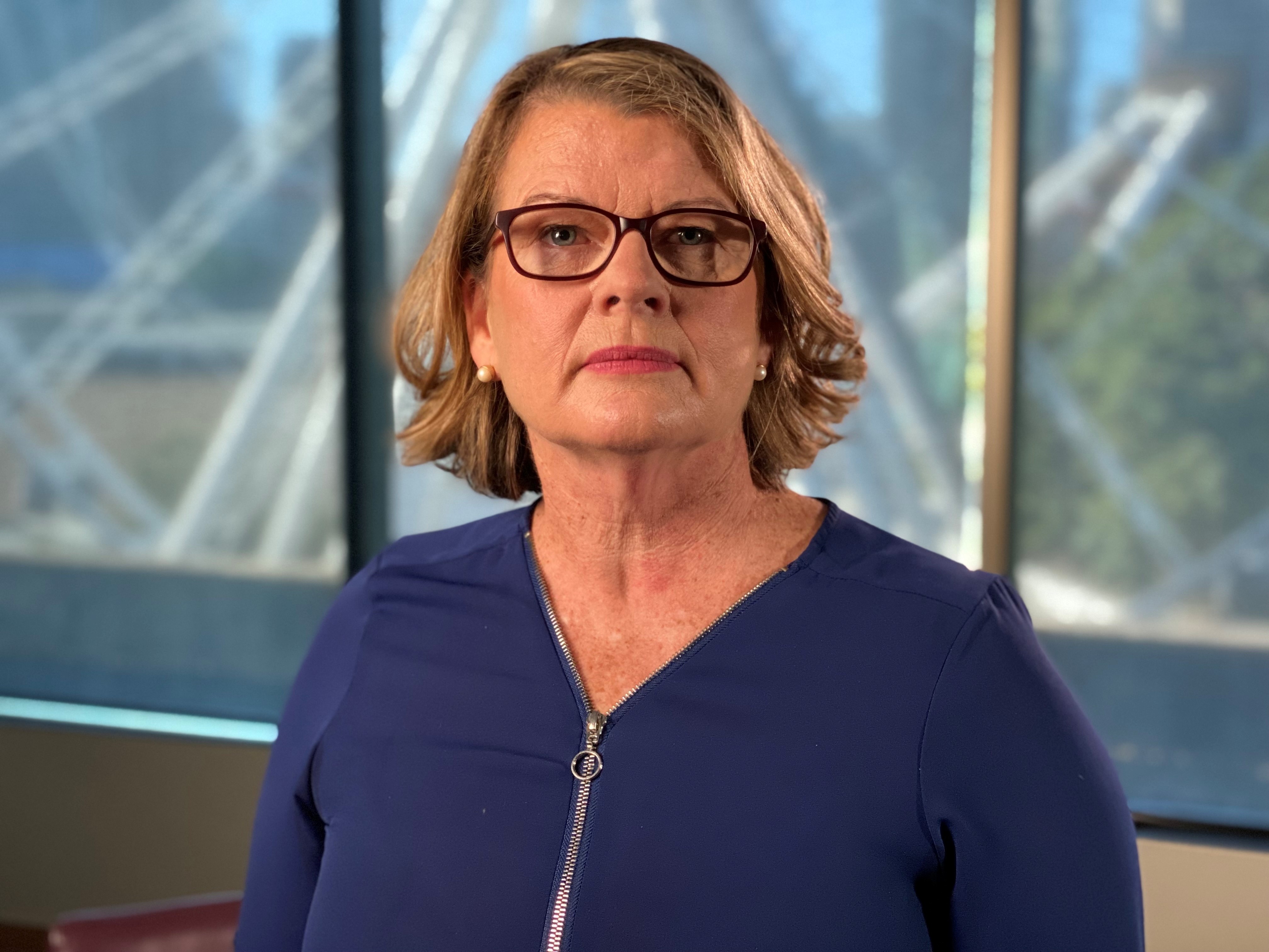 Woman wearing glasses and a blue top.