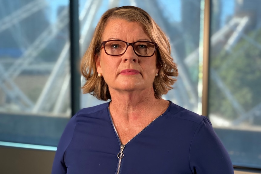 Woman wearing glasses and a blue top.