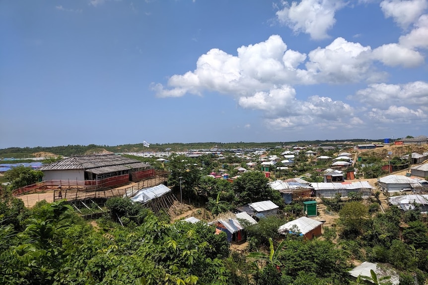 Clear blue skies stretch over huts made out of tarpaulin and bamboo as far as the eye can see.