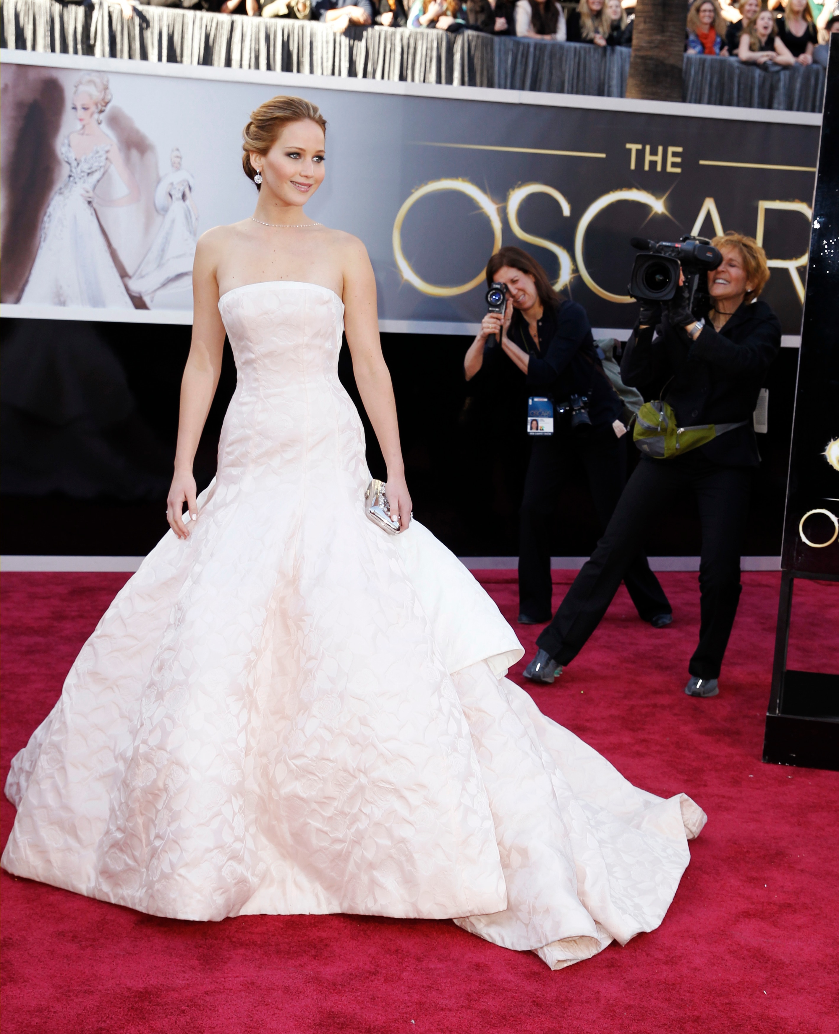 Jennifer Lawrence in a strapless, very plae pink dress with a full structured skirt
