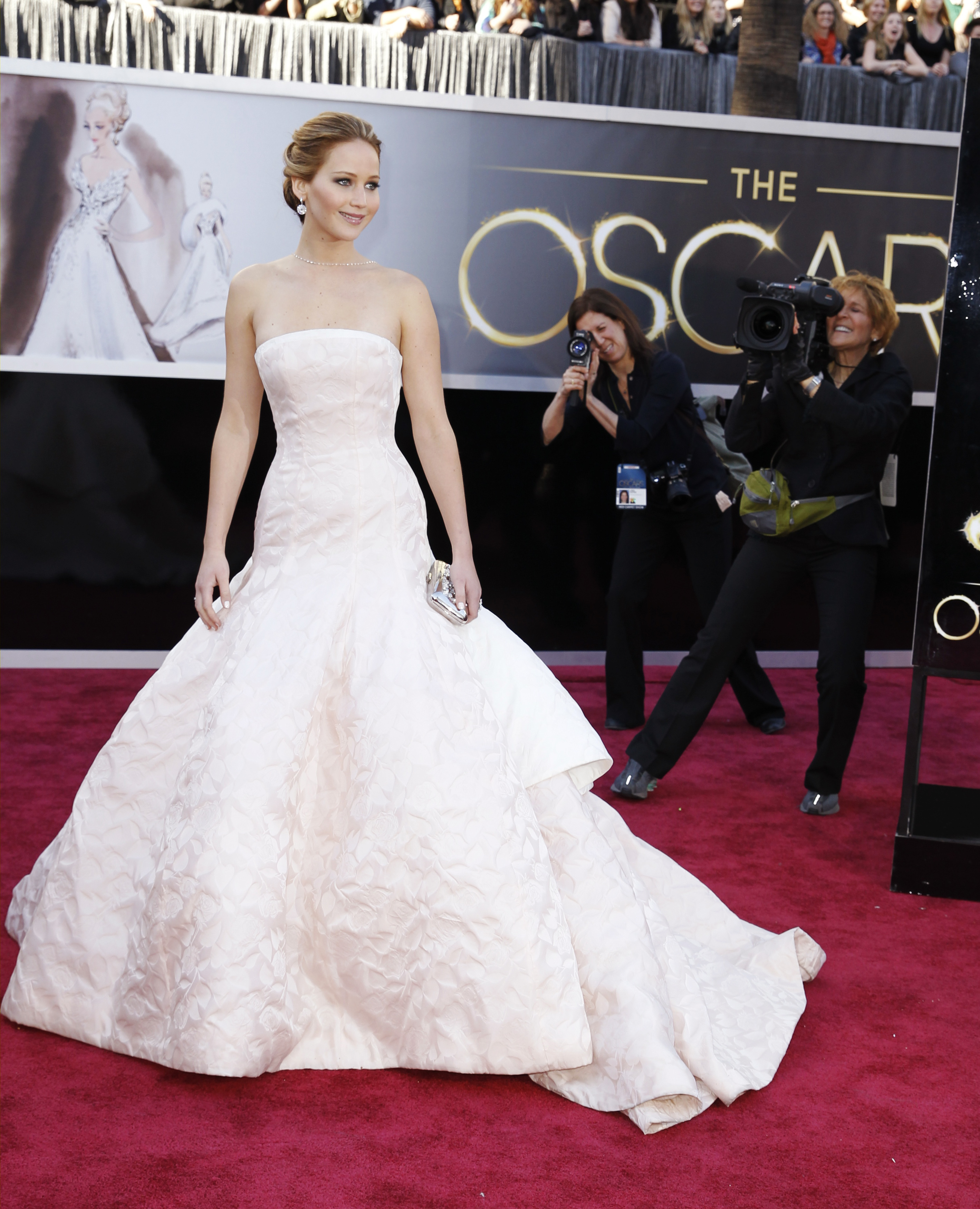 Jennifer Lawrence in a strapless, very plae pink dress with a full structured skirt