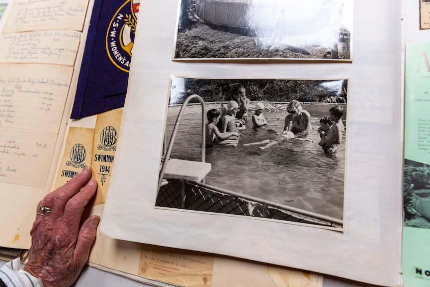 Old photos of a woman teaching kids how to swim, stuck in a photo album