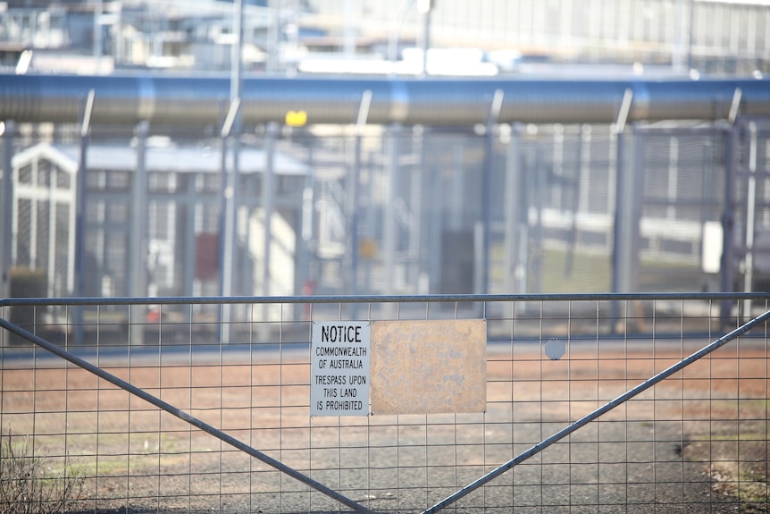 A gate with a warning sign on it outside Yongah Hill immigration detention centre.