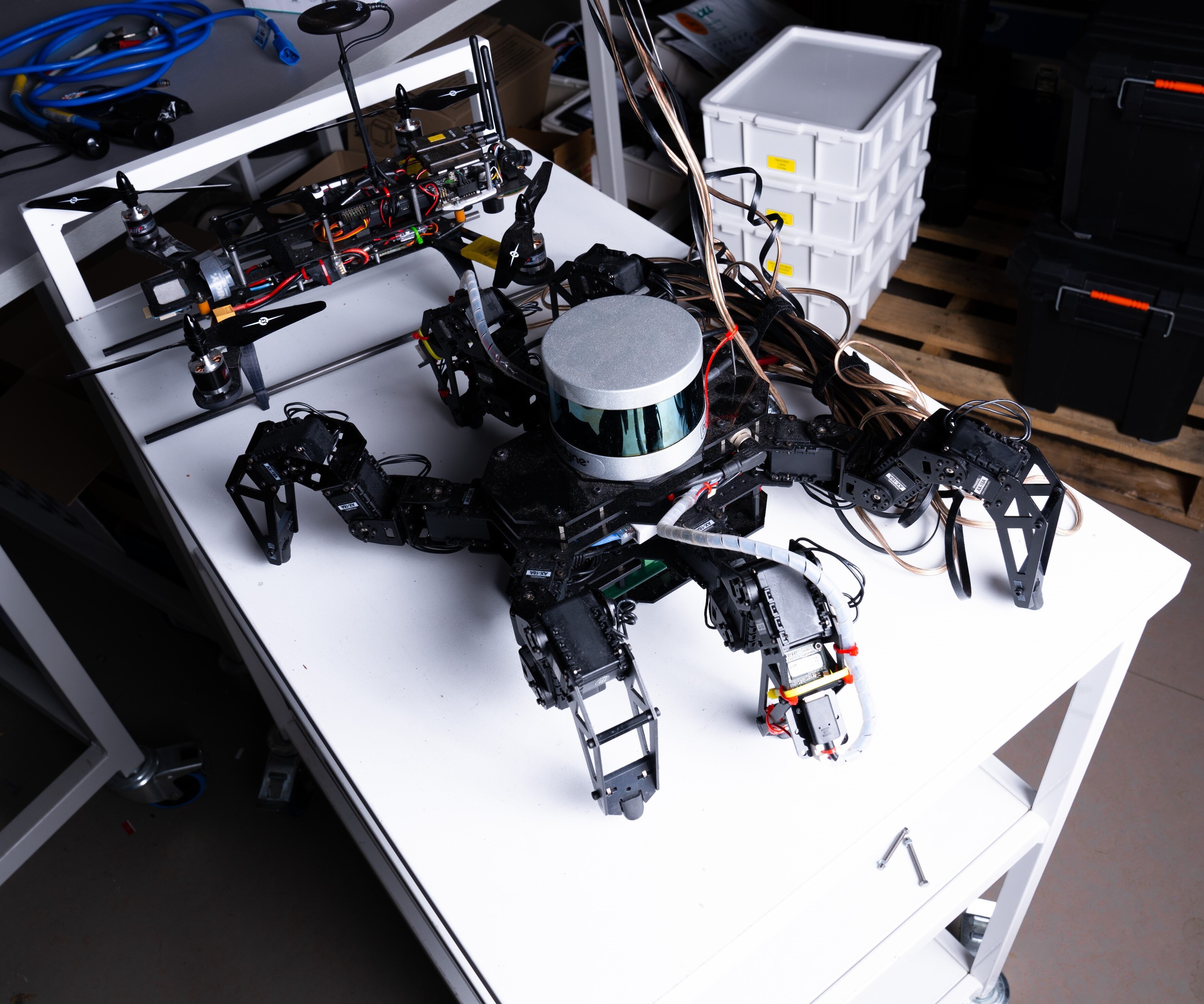 A black robot on a table surrounded by wires