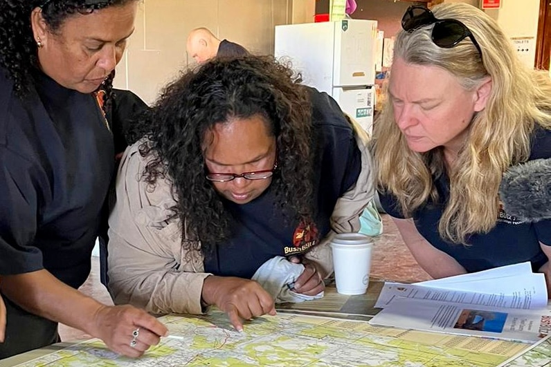 Three women looking at a map.
