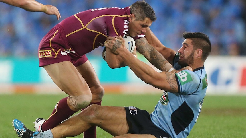 Corey Parker of the Maroons is tackled by the Blues's James Tamou in Origin I, 2013.