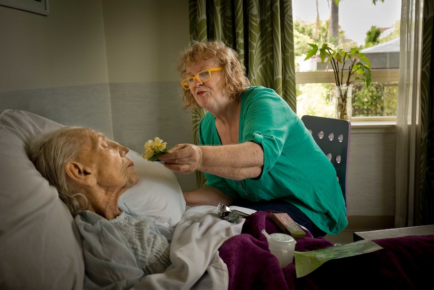 Marion Rae holds a flower to her mother Margaret who has dementia.