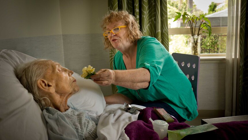 Marion Rae holds a flower to her mother Margaret who has dementia.
