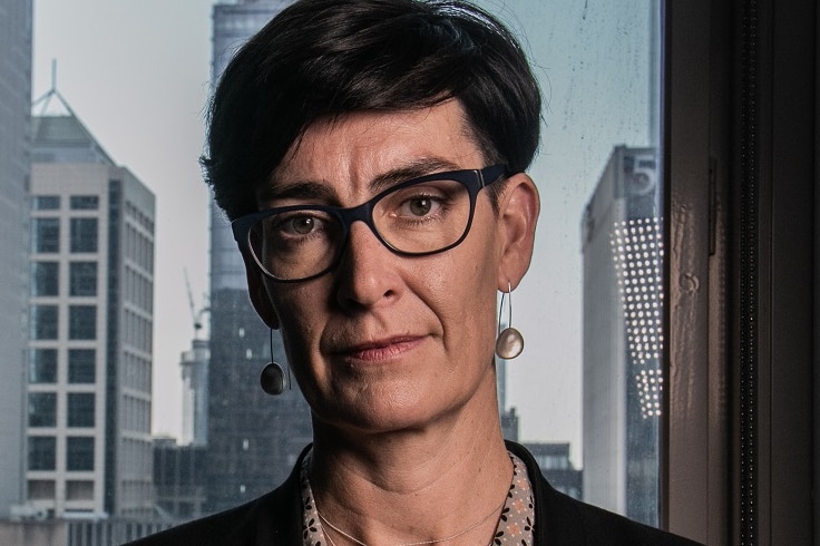 A portrait picture of Liana Buchanan looking at the camera, with the city skyline behind her.