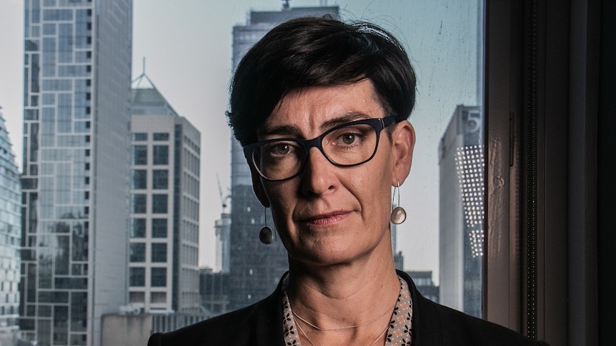 A portrait picture of Liana Buchanan looking at the camera, with the city skyline behind her.