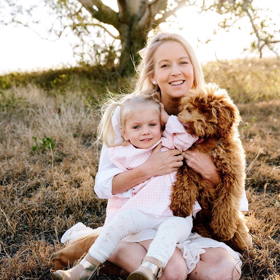 Kate Willis holding her daughter and a puppy.