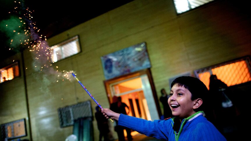 A boy lights a cracker in Tehran