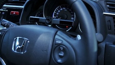 Seeing Machines eye-tracking technology sitting on top of the middle of the steering wheel in front of dash board.