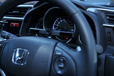 Seeing Machines eye-tracking technology sitting on top of the middle of the steering wheel in front of dash board.