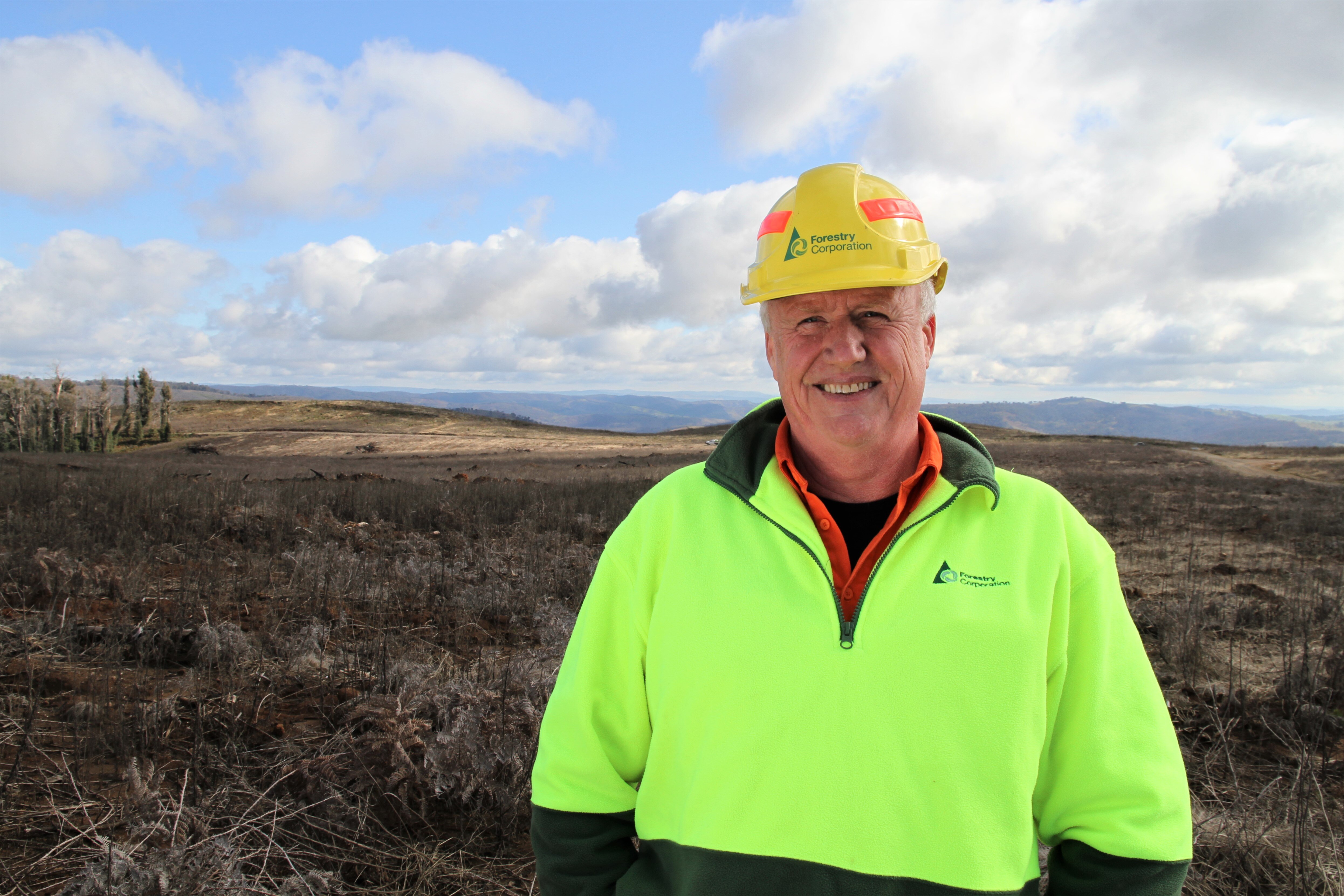 cameroon timber A man wearing a hard hat.