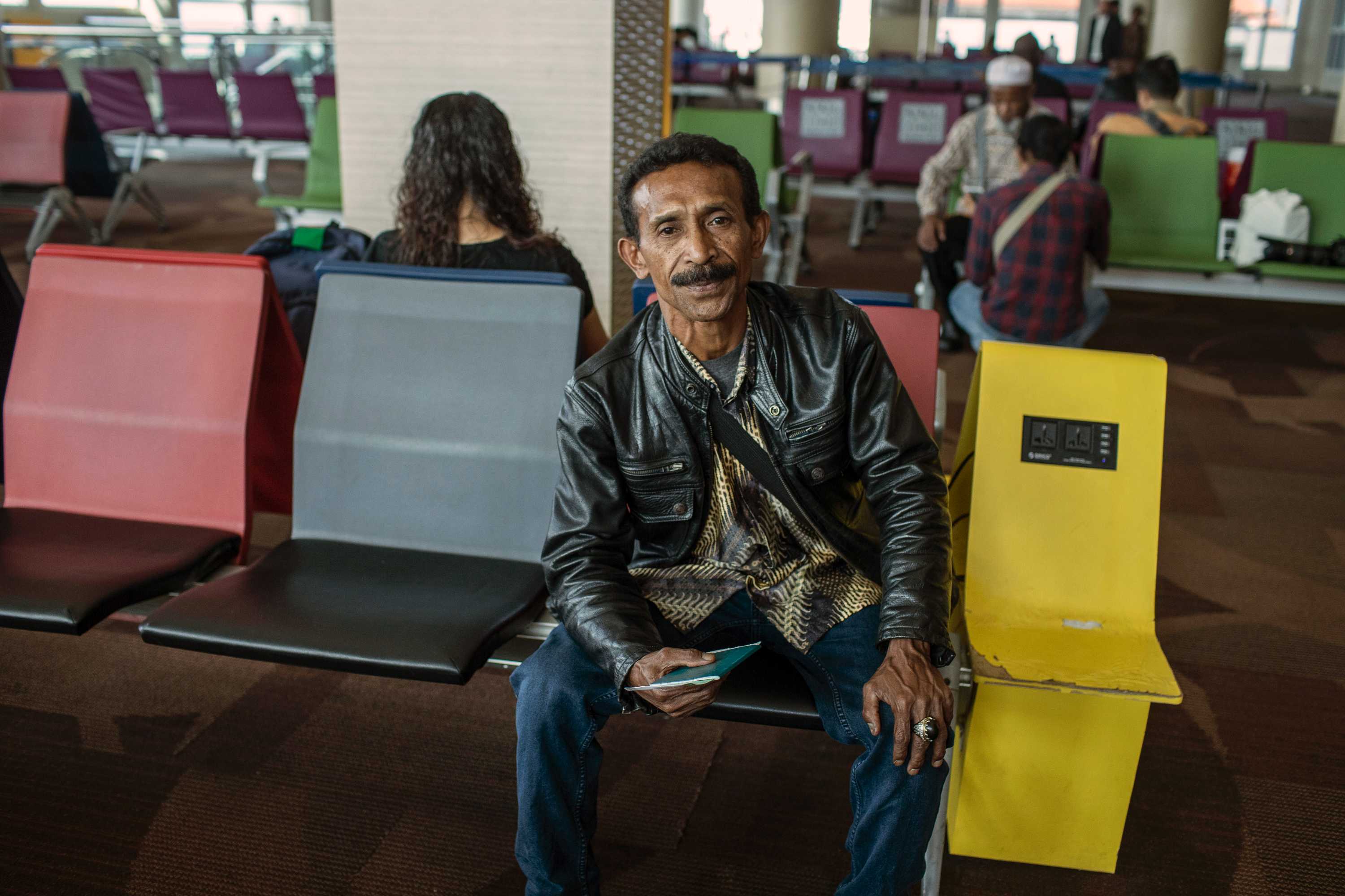 Alis holds his passport.