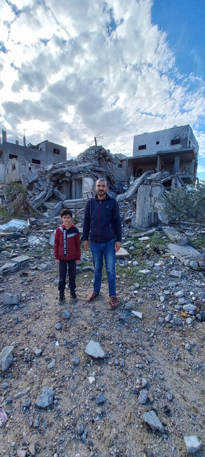 Alaa and his son at the site of their home which has now been reduced to rubble. 