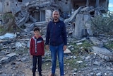 Alaa and his son at the site of their home which has now been reduced to rubble. 