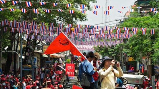 Protesters and journalists fill a Bangkok street