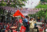 Protesters and journalists fill a Bangkok street