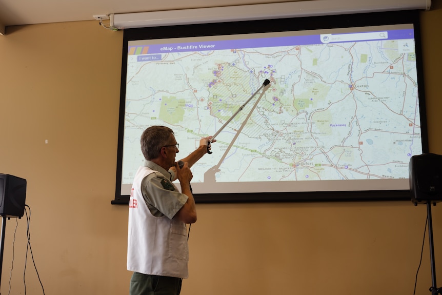A man points to an area on a map.
