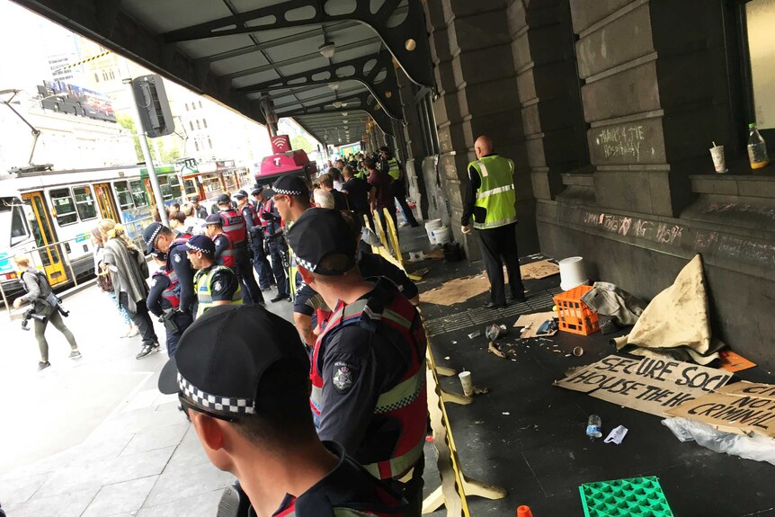 Police remain on guard after removing homeless people from Flinders Street Station.