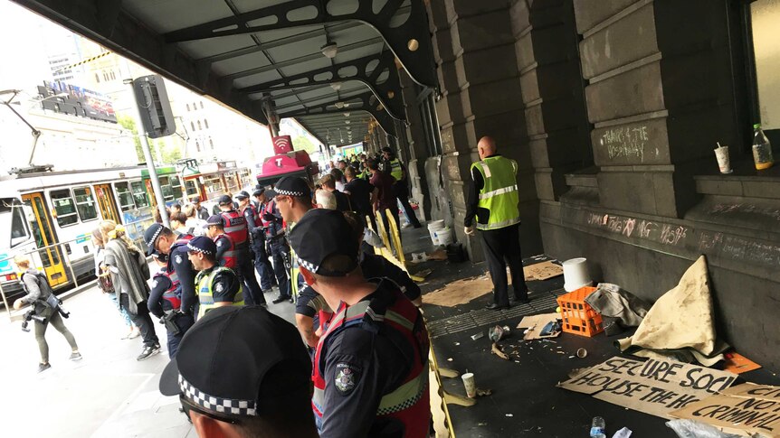Police remain on guard after removing homeless people from Flinders Street Station.