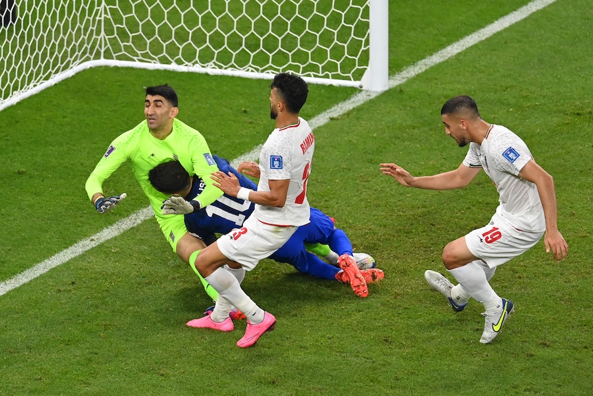 Christian Pulisic slams face first into Iran's goalkeeper near the goal line