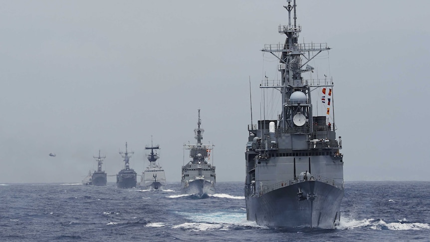 Kee Lung (DDG-1801) guided-missile destroyer (R) and navy vessels take part in a military drill near Hualien