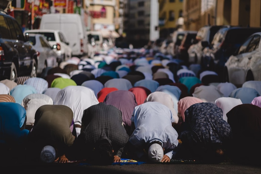 Muslims kneeling in prayer for Eid.