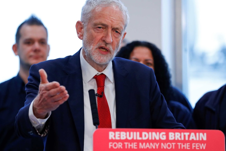 Jeremy Corbyn at a lectern that reads Rebuilding Britain