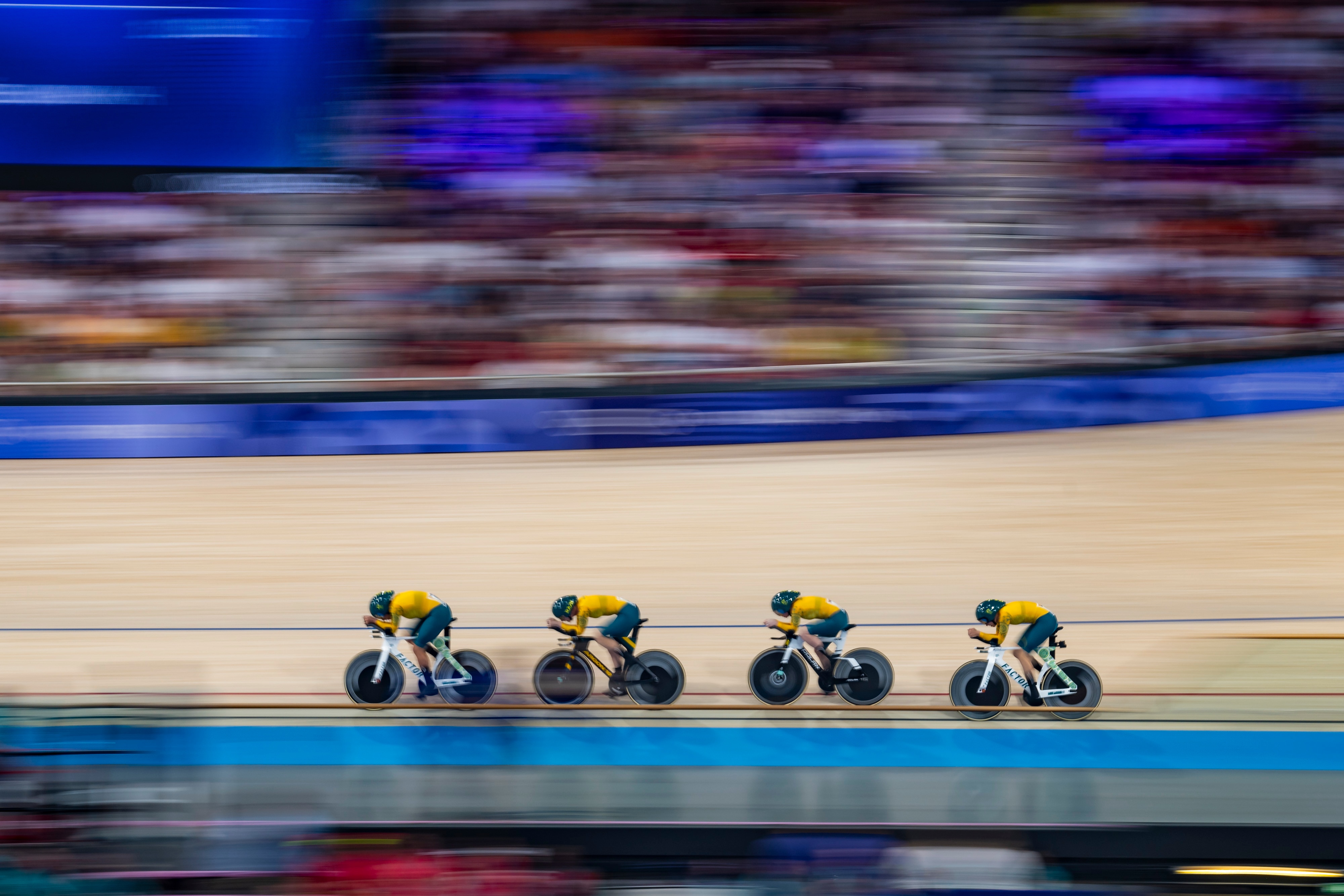 a group of cyclists compete at a velodrome
