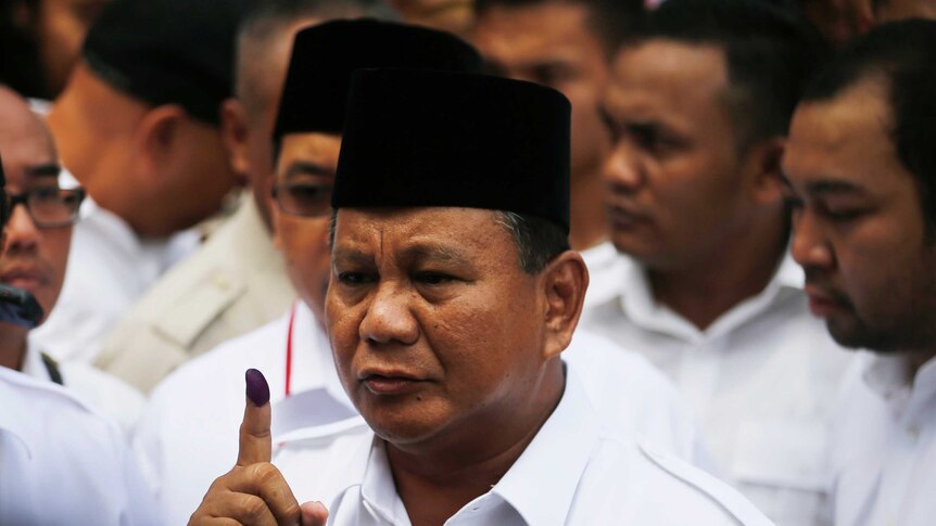 Prabowo Subianto shows his finger after voting in Bogor, Indonesia