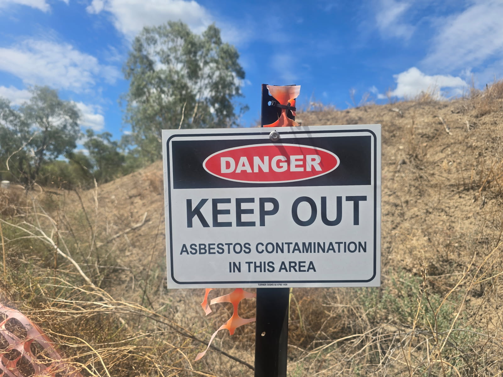 A sign warning of asbestos contamination.