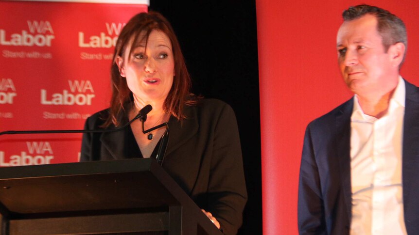 Labor's Darling Range candidate Tania Lawrence speaks on stage with Mark McGowan standing nearby.