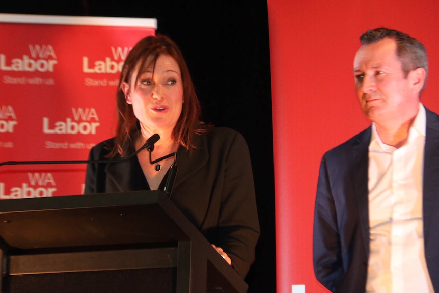 Labor's Darling Range candidate Tania Lawrence speaks on stage with Mark McGowan standing nearby.