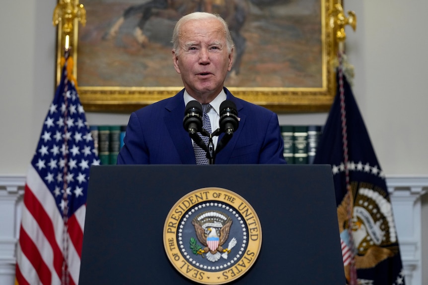 Joe Biden stands in front of presidential podium 