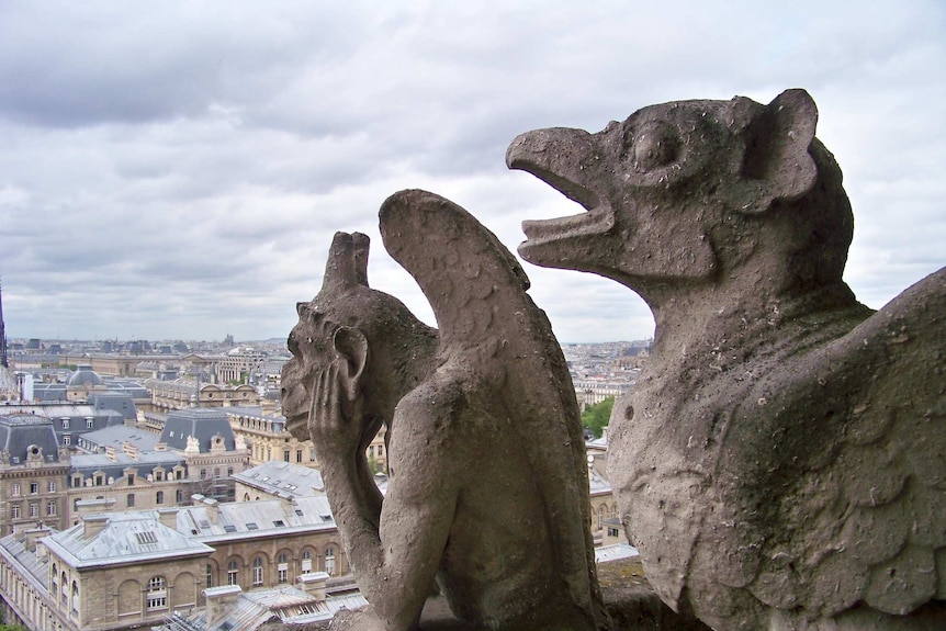 A stone gargoyles on top of the Notre Dame cathedral.