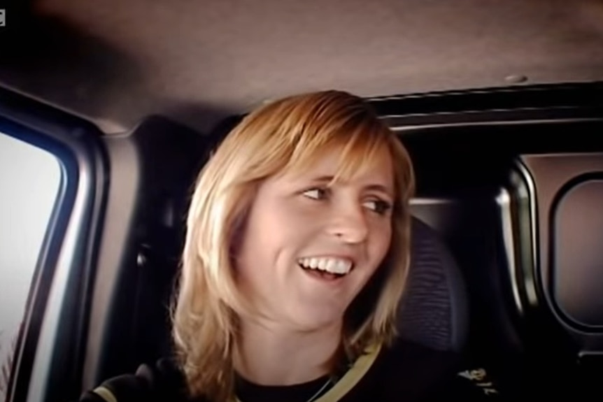 Sabine Schmitz smiles and looks to her left