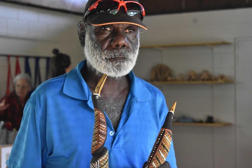 Graham Tipungwuti holds two birds he carved and painted.