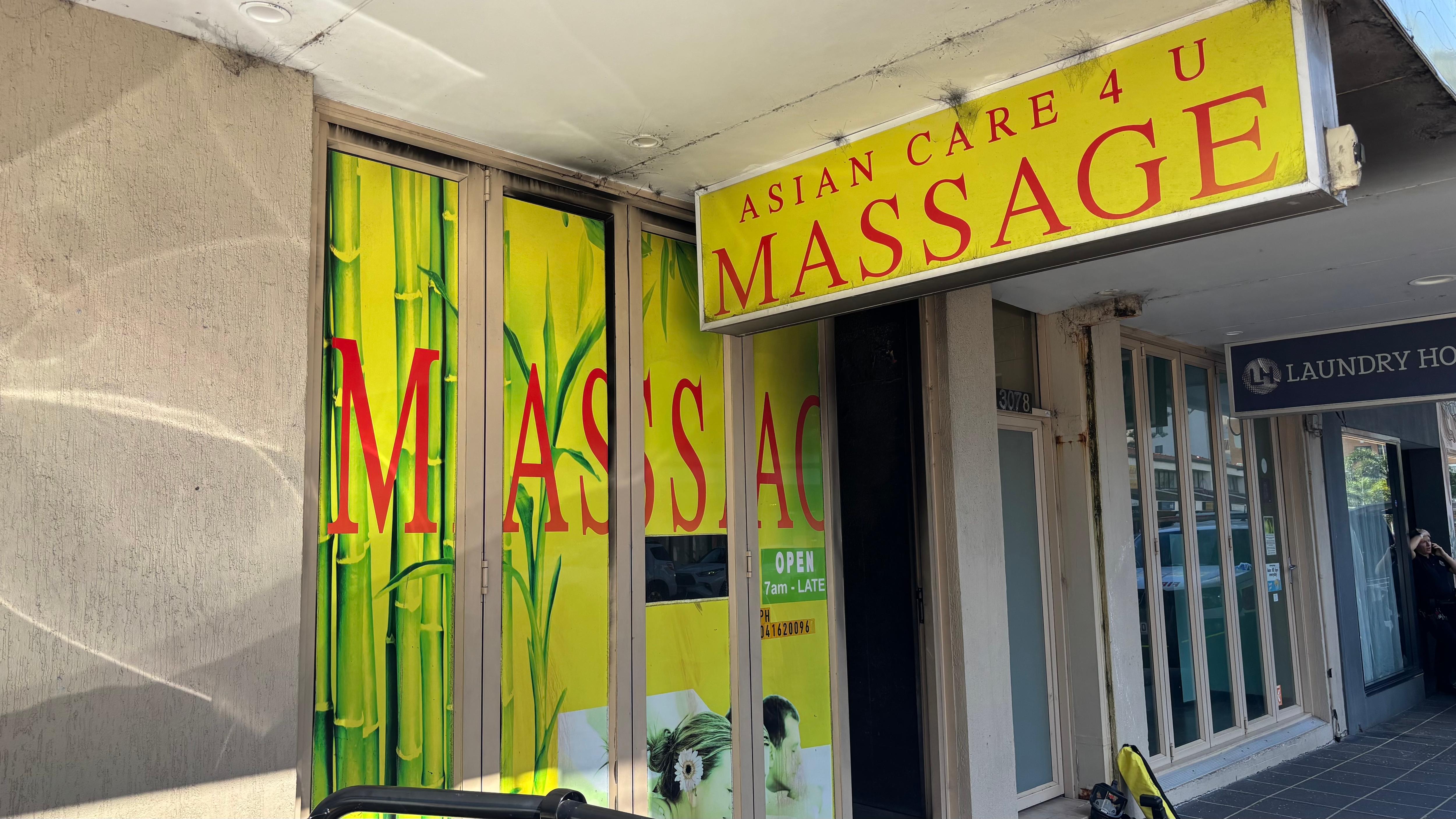 The outside of a massage parlour business with signs of fire damage