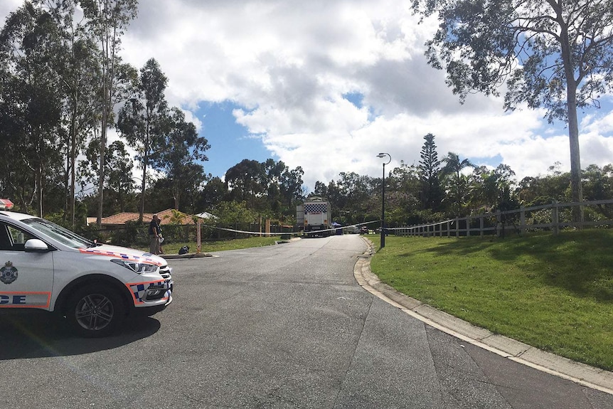 Police car and forensic truck at scene where a woman's body was found on the road at Worongary.