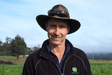 Pemberton potato grower Glen Ryan in black jumper and hat, with fields in the background.