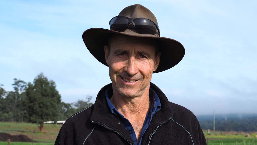 Pemberton potato grower Glen Ryan in black jumper and hat, with fields in the background.