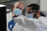 Prime Minister Scott Morrison next to a man holding a vaccine vile