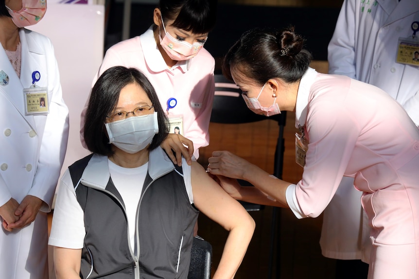 Tsai Ing-wen receives an injection from a nurse.